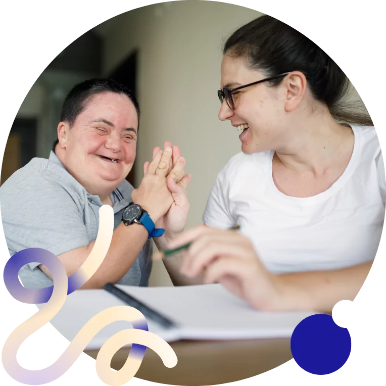 Disabled woman and her support worker high fiving