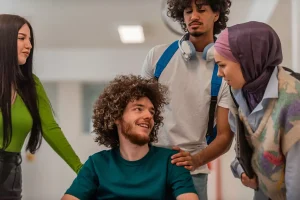 A disabled man sitting in his wheelchair talking with his friends